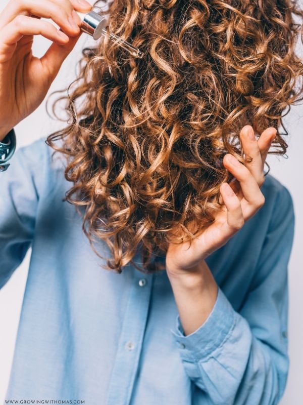 Applying-a-few-drops-of-oil-to-the-hair-ends