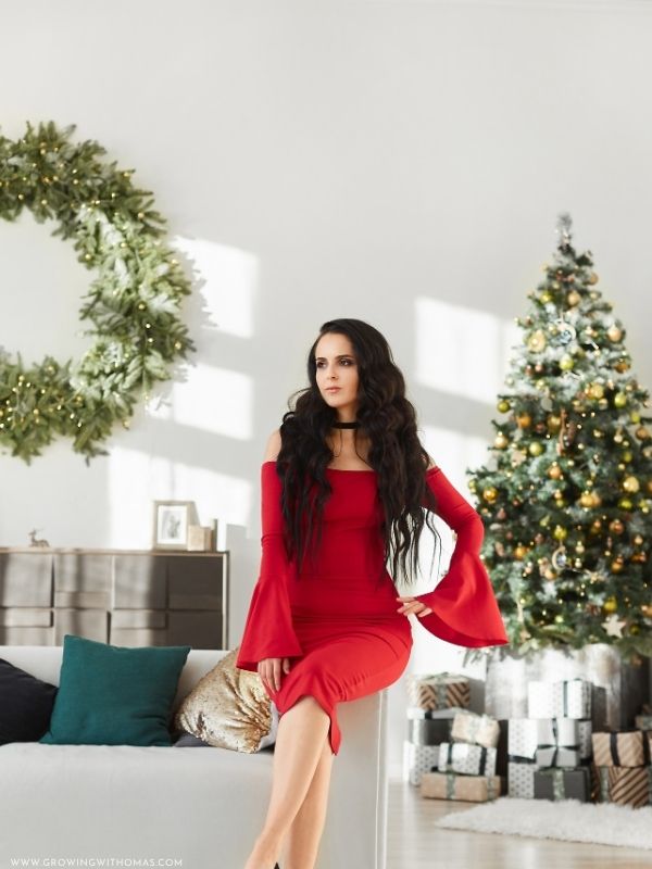 Elegant-woman-wearing-a-red-Christmas-dress-posing-near-Christmas-lights