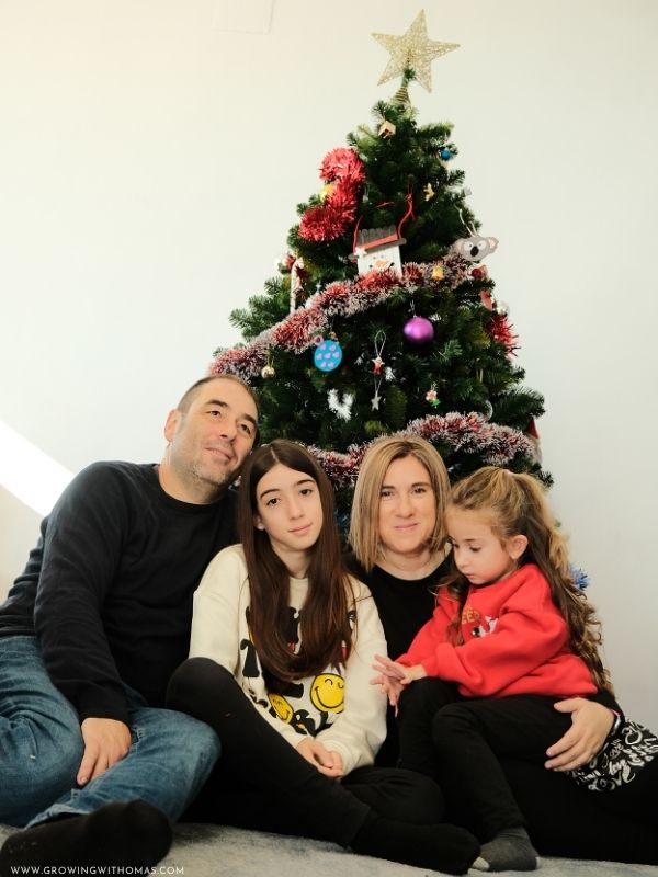 Happy-family-posing-together-for-a-Christmas-portrait-beside-a-decorated-Christmas-tree
