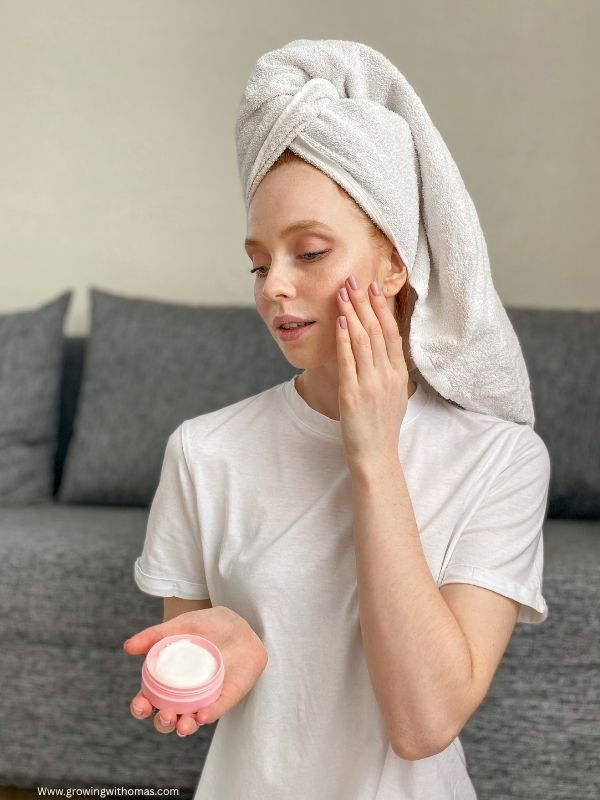 a-lady-appying-moisturizer-to-her-face