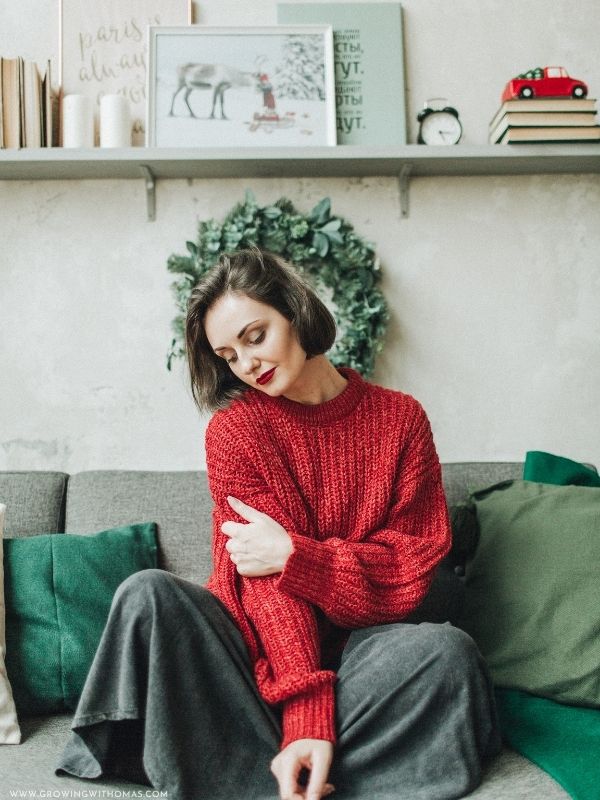 Woman-wearing-a-cozy-Christmas-sweater-with-a-stylish-midi-skirt-at-home