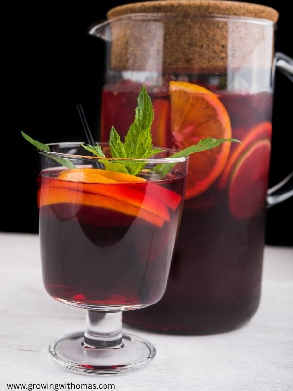 A-Christmas-hibiscus-drink-served-in-clear-glasses-with-orange-slice-in-non-alcoholic-christmas-drinks