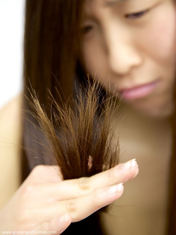 a-woman-holding-her-hair-with-split-ends